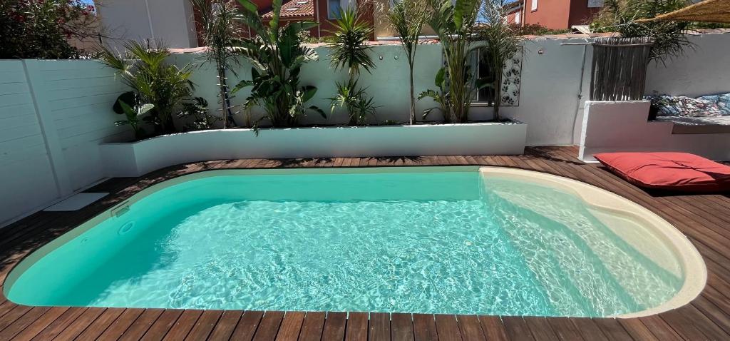une petite piscine au milieu d'une terrasse en bois dans l'établissement Villa Les Dunes, à Frontignan
