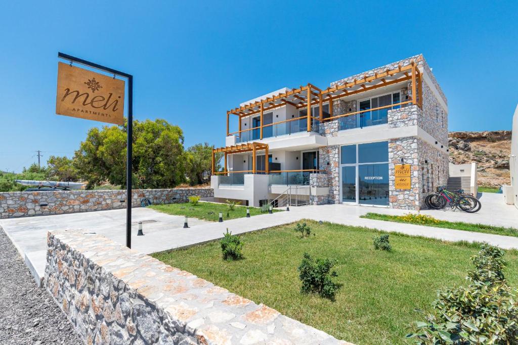 a building with a sign in front of it at Meli apartments Paleochora in Palaiochora
