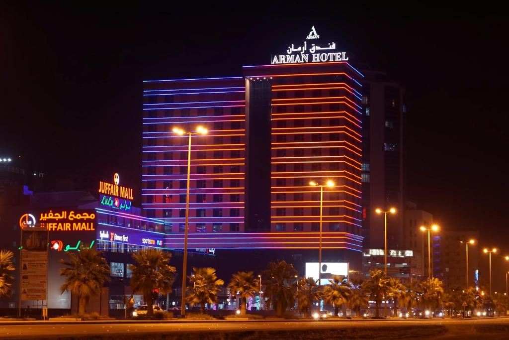 Arman Hotel Juffair Mall في المنامة: فندق اخاتر اضاءه باللون الأزرق ليلا