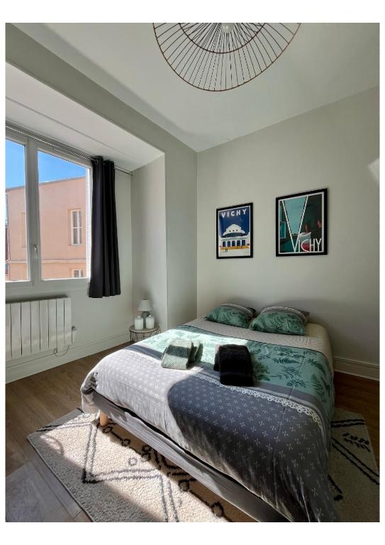 une chambre avec un lit et une grande fenêtre dans l'établissement Appartement Vichy - Hyper Centre, à Vichy
