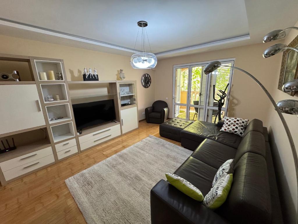 a living room with a couch and a television at Comfortable family apartments in Przno in Pržno