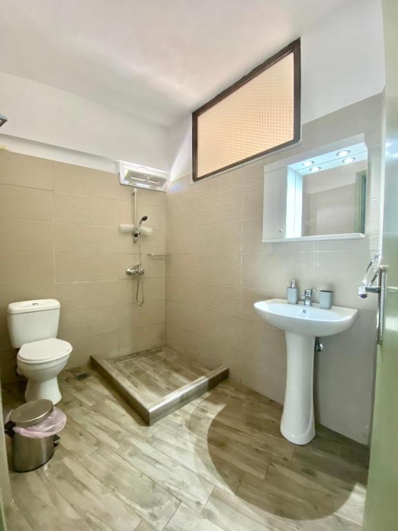 łazienka z umywalką, toaletą i lustrem w obiekcie Summer Rooms w mieście Skala Kallirachis