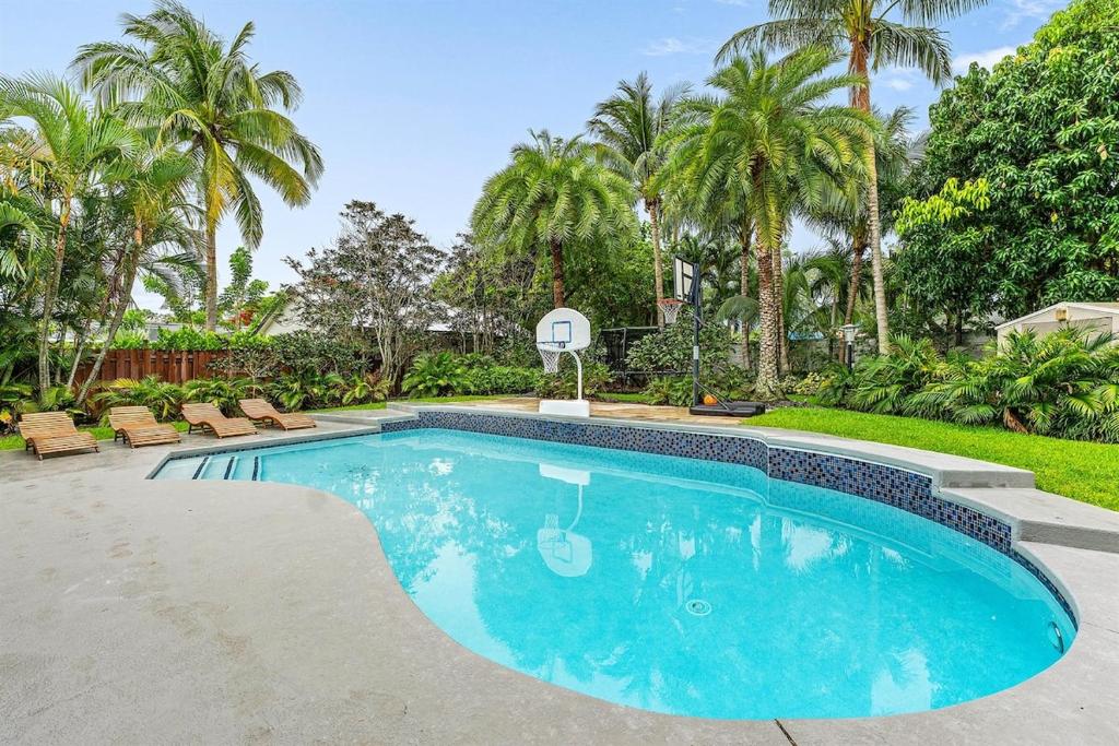 a swimming pool in a yard with palm trees at Hot Tub Salt Pool Png Png 5 Min to AtlAv Trampline in Delray Beach