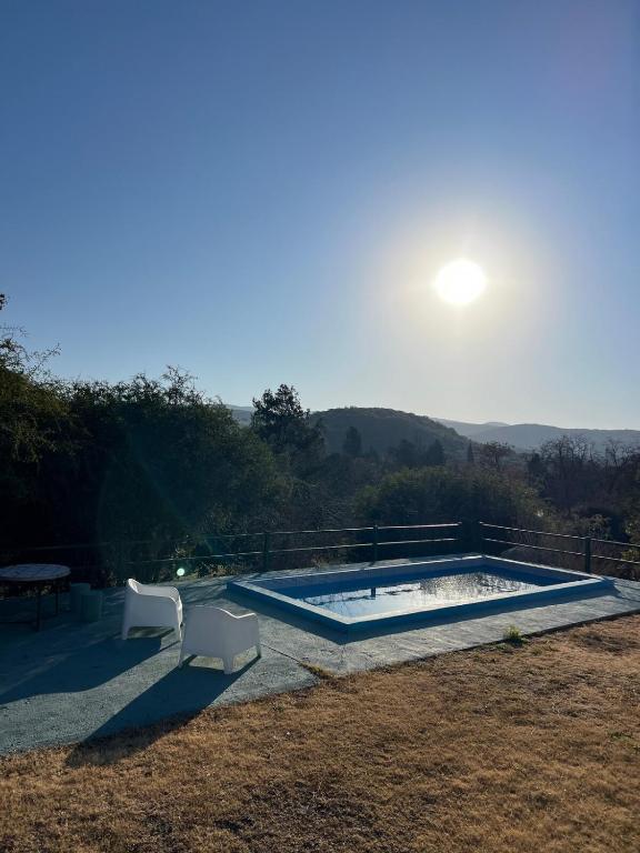 a swimming pool with the sun in the background at El Nacimiento 2 in La Granja