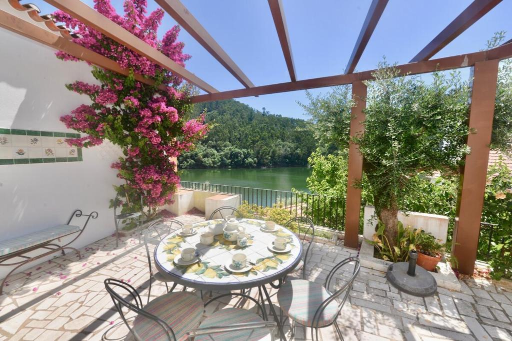 a table and chairs on a patio with a view of a lake at Riverside - Lovely river-view 3 bedroom house in Dornes