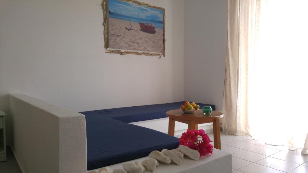 a living room with a blue bed and a table at Esperos Hotel in Troulos