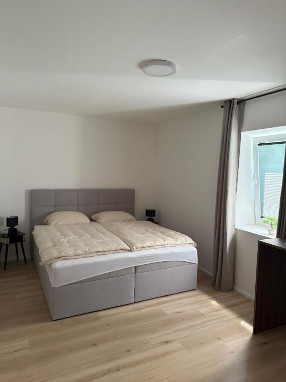 a white bedroom with a bed in a room at ALS Zimmer & Suiten in Lambach