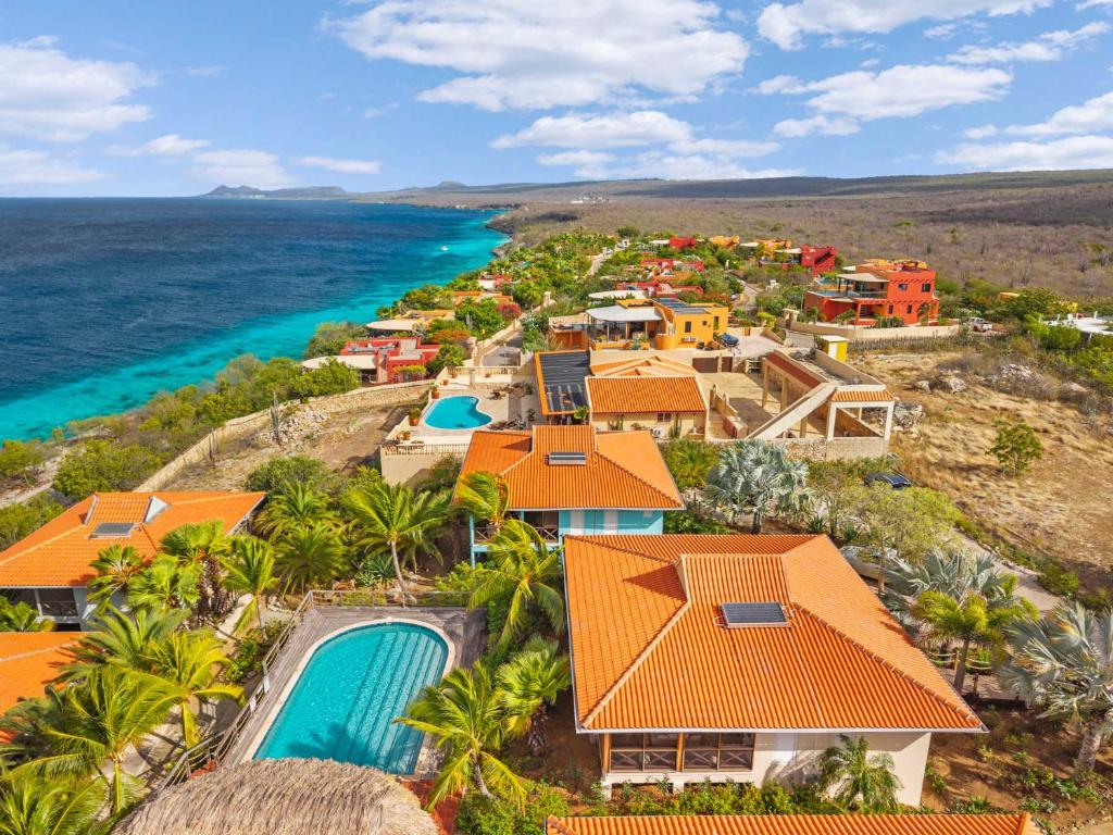 an aerial view of a resort with a pool and the ocean at Villa Happy Turtle with a spectacular ocean view in Kralendijk