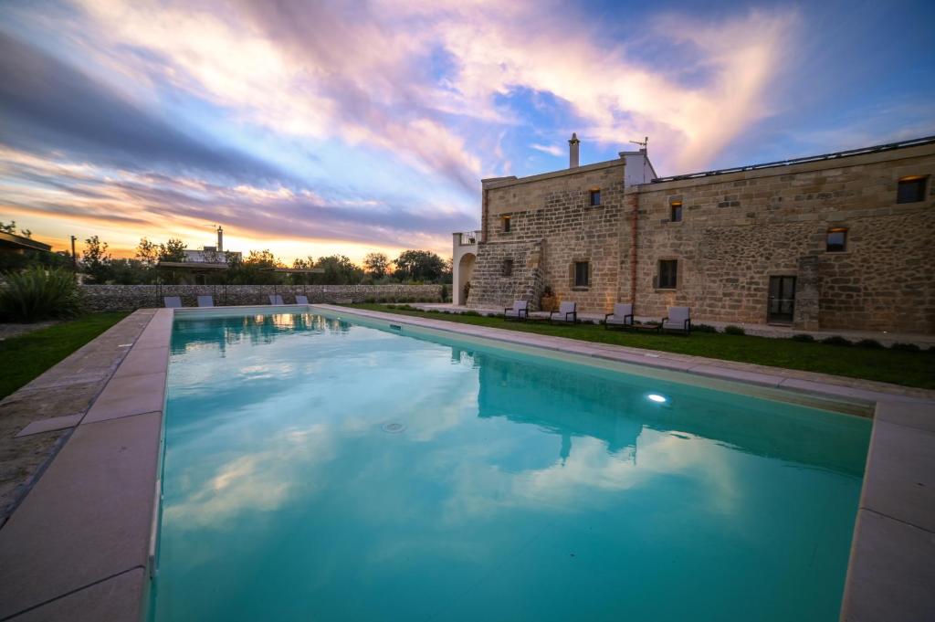 a large swimming pool in front of a building at Masseria Casina Fiocca in Pisignano