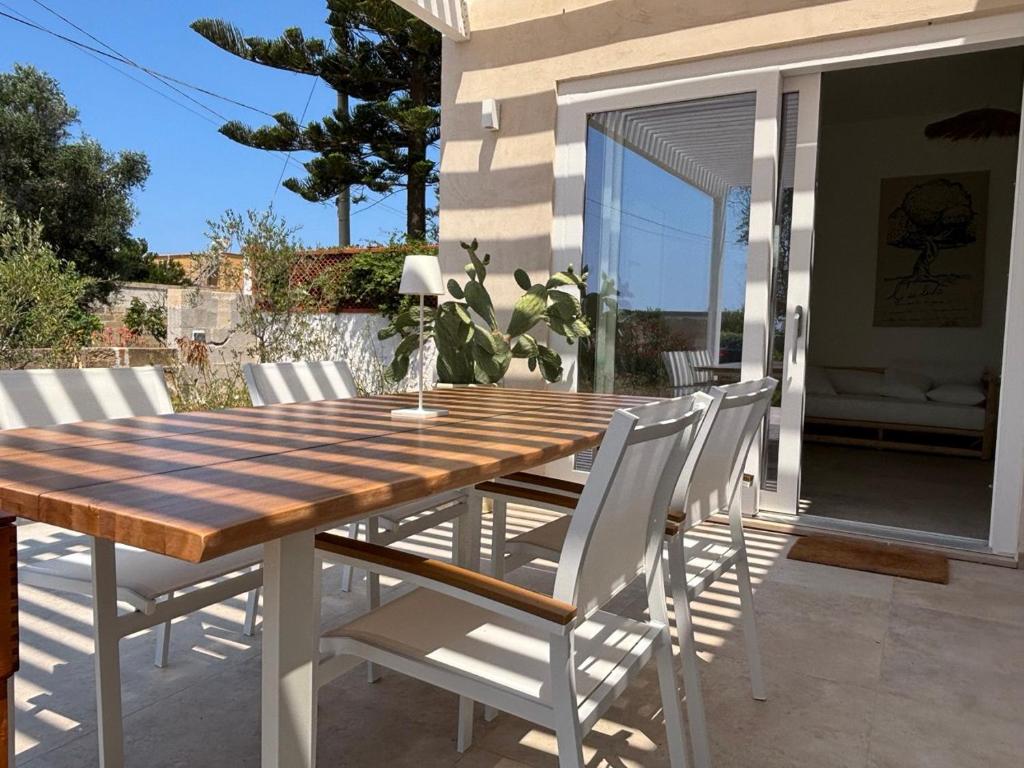 ein Holztisch und Stühle auf einer Terrasse in der Unterkunft Casa Ulivo in Capilungo