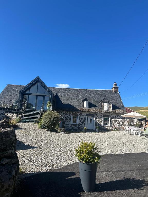 une grande maison en pierre avec un toit dans l'établissement Chez Mary Elise, à Le Claux