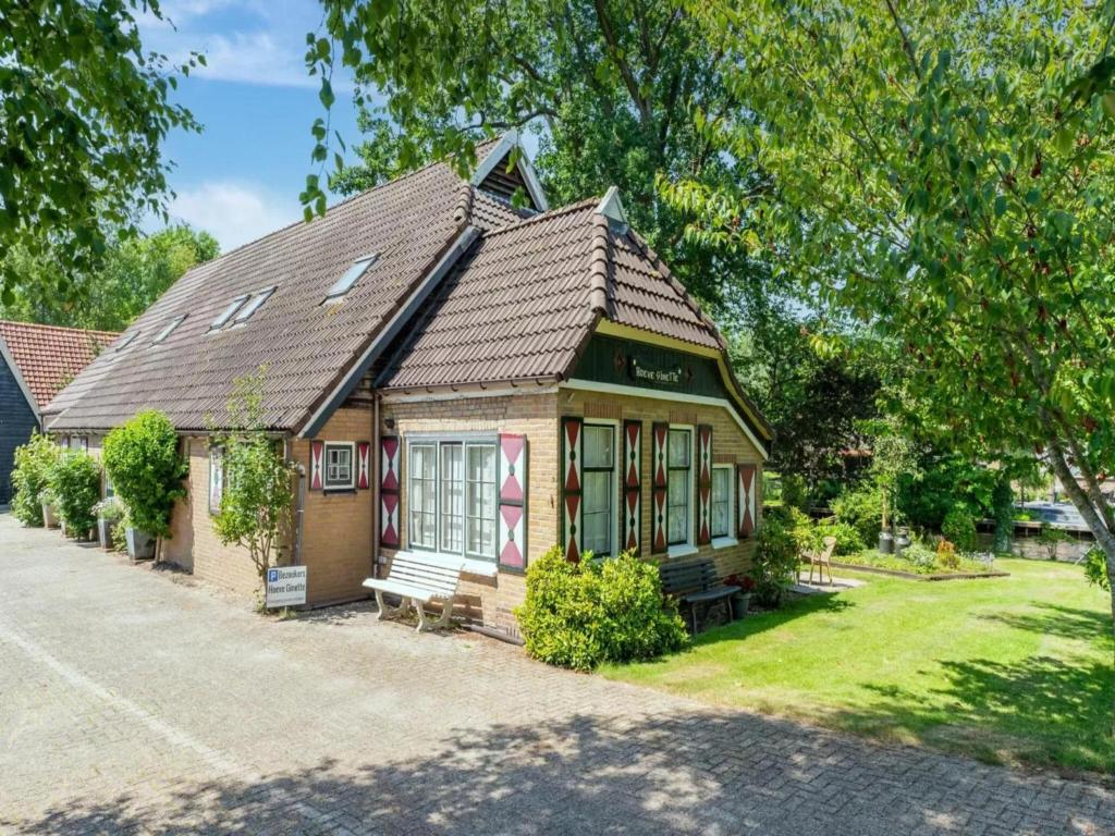 a small house with a bench in front of it at Benedenverdieping Hoeve Ginette in Giethoorn