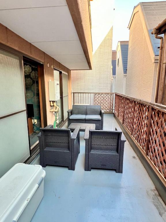 a patio with chairs and a table on a balcony at ペットと泊まれる Tatami & B 池上 202 2DK 40m2 in Tokyo