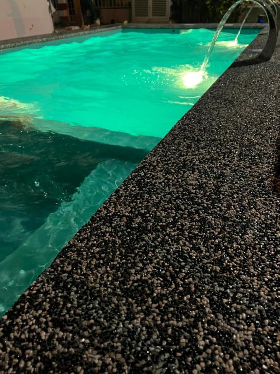 a swimming pool with a light on the water at The White House Nilai Impian in Nilai