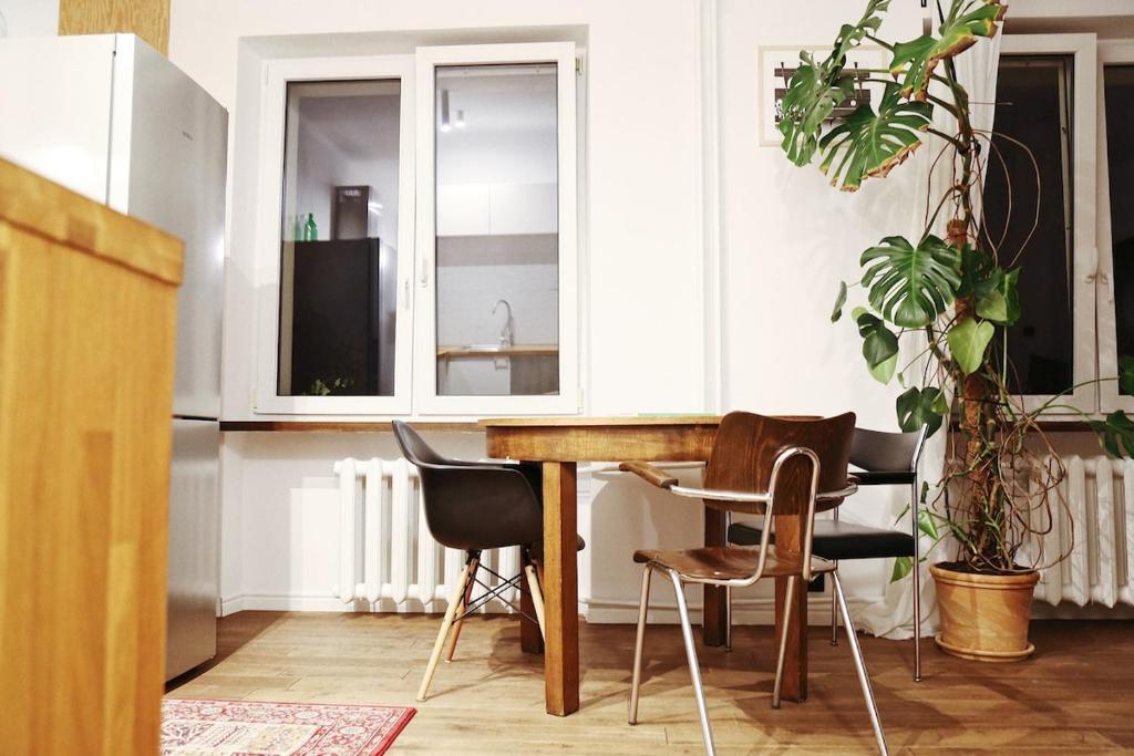 a kitchen with a wooden table and chairs at Comfy open-space apartment in Warsaw Zoliborz in Warsaw