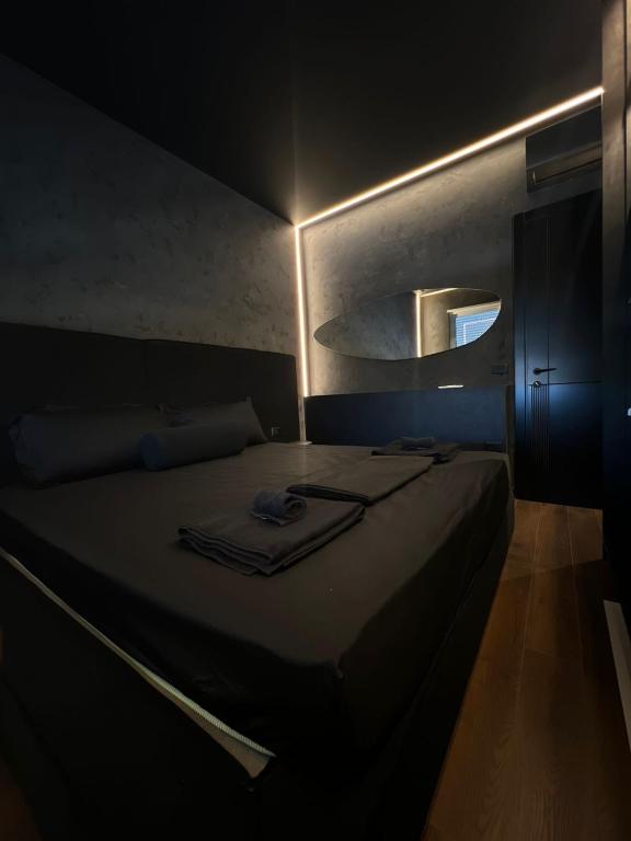 a dark room with a bed with a mirror at Iunn Apartment 5 in Vlorë