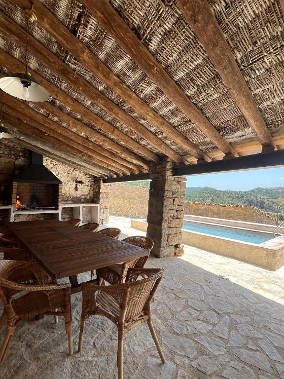 a dining room with a wooden table and chairs at Masía La Perera in Morella