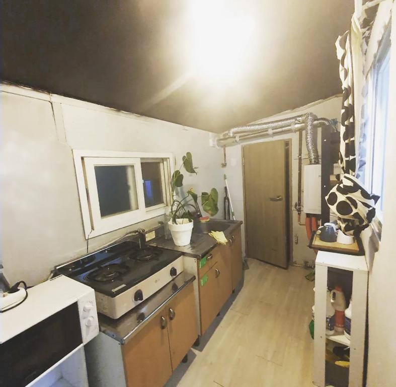 Una cocina con estufa y fregadero. en Isu Art Retreat 이수 아트 리트릿, en Seúl