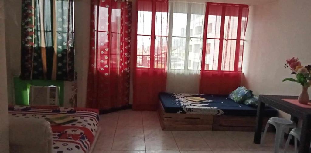 a room with red curtains and a bed and a table at Condotel Cebu City in Cebu City