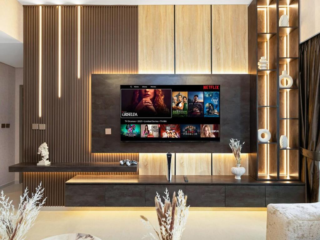 a living room with a flat screen tv on a wall at 51st Floor Sea and Skyline Views LUXE 1BR in Dubai