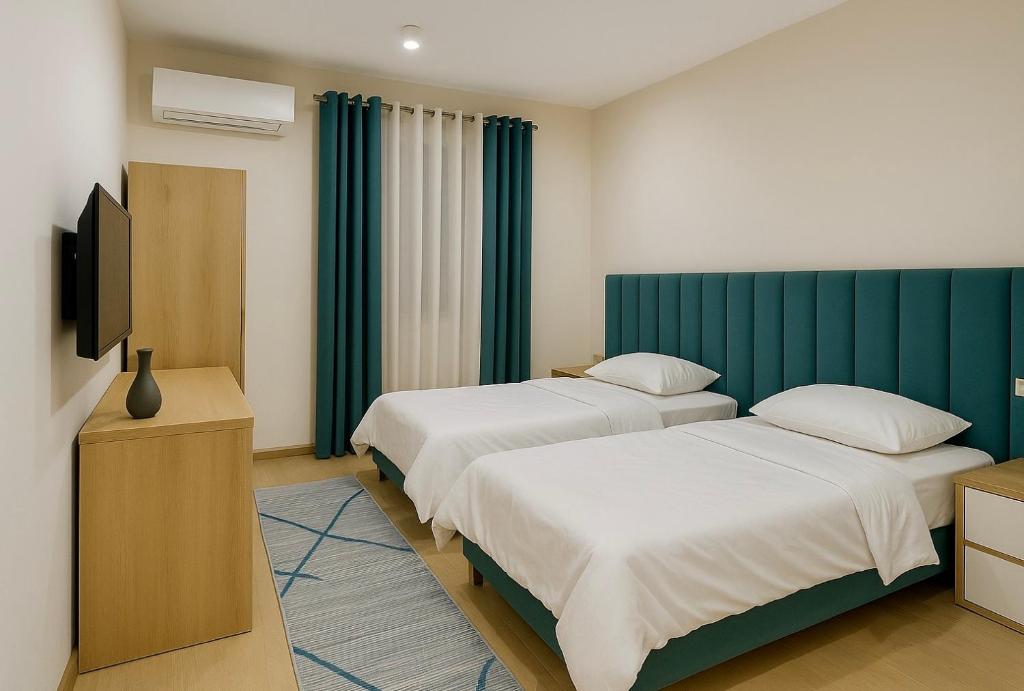 a hotel room with two beds and a television at Hotel Krial in Berat