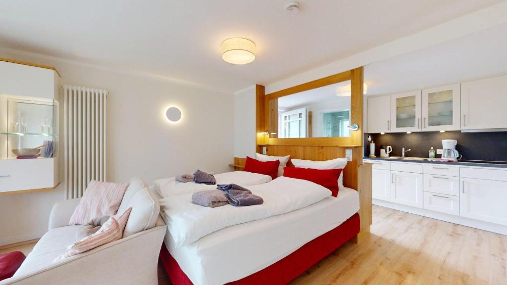 a bedroom with a large bed with red and white pillows at Haus Ostwind OSTWIND 'Lütje Pläseer' in Langeoog