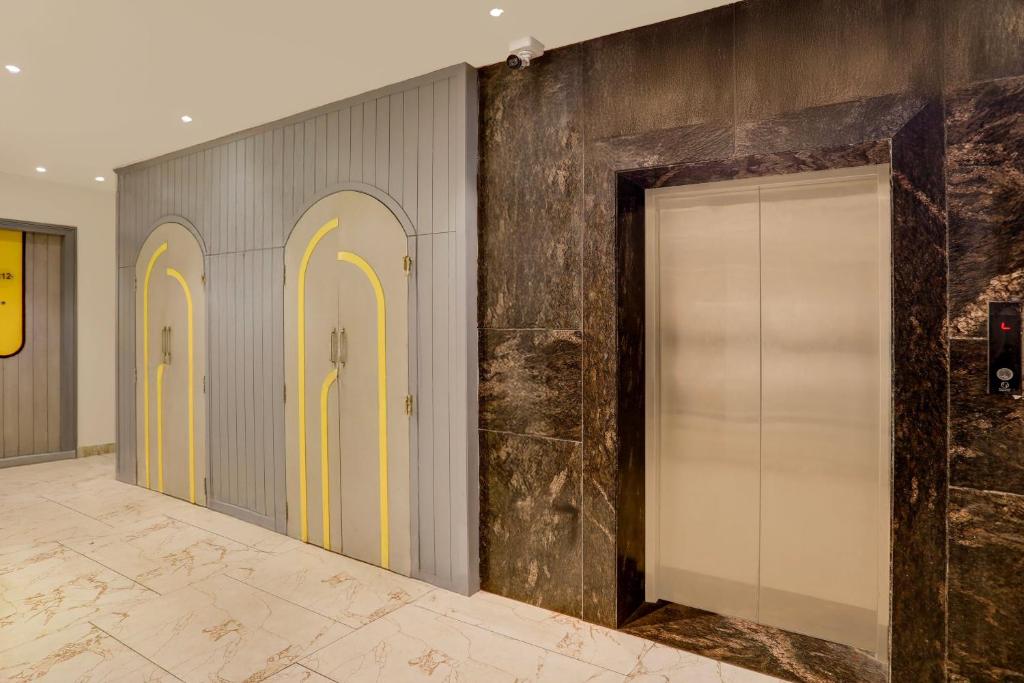 a row of elevators with yellow doors in a hallway at Super Townhouse Vaishali Nagar Jaipur Formerly Pentagon Boutique Hotel in Jaipur