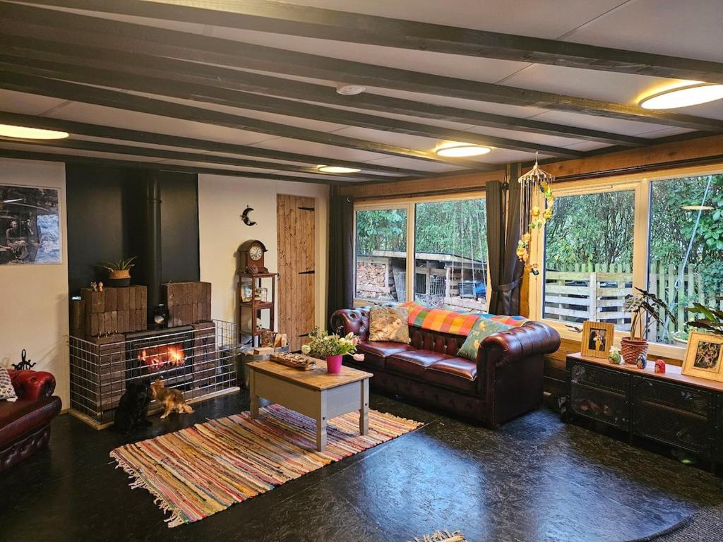 un salon avec un canapé et une cheminée dans l'établissement Quirky&Old Cottage for Families, à Colyford