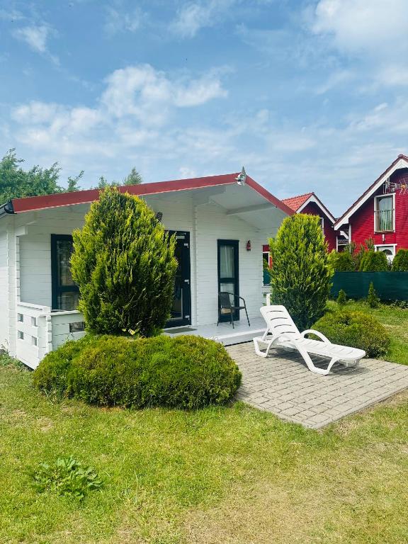 a white bench sitting in front of a house at Domki Marina Rowy in Rowy