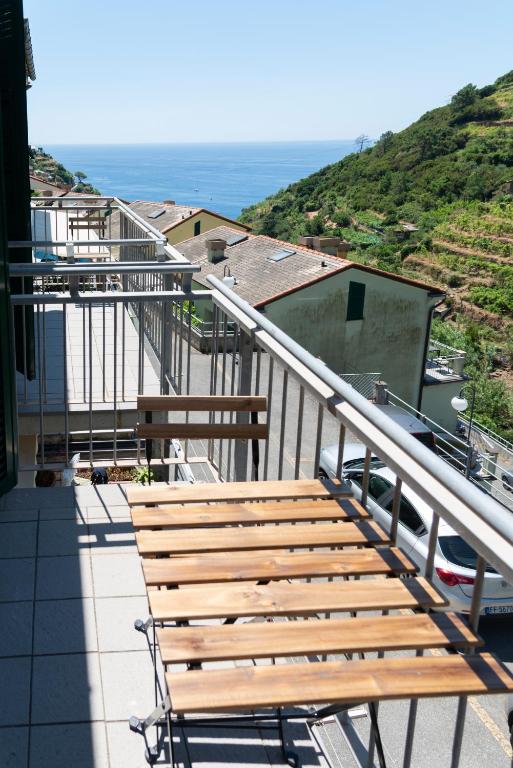 a wooden bench sitting on top of a balcony at Le Terrazze di katia rooms in Riomaggiore