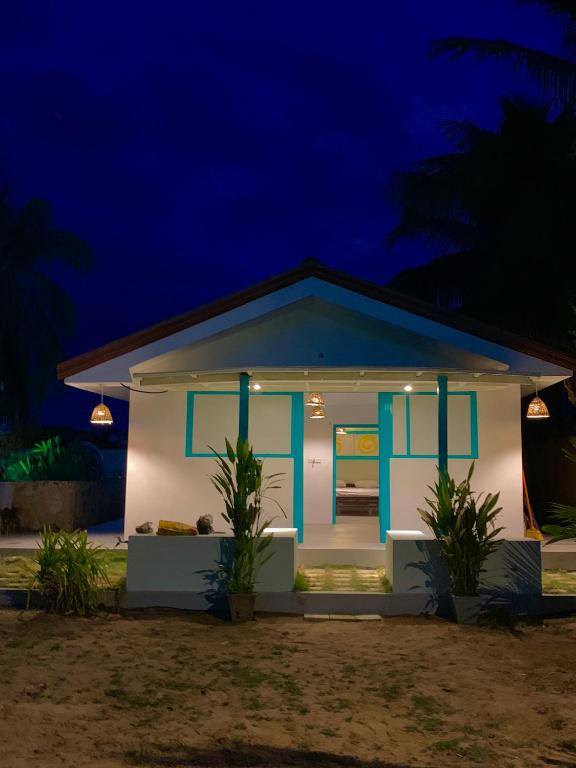 a small white house with blue doors at night at Sun Rock Villa Arugambay in Arugam Bay
