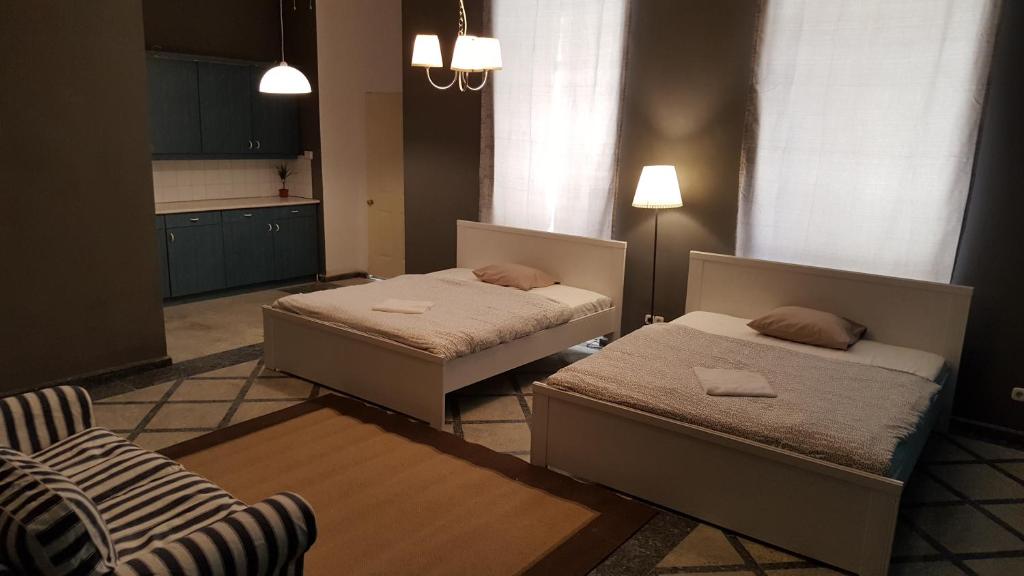 Un dormitorio con 2 camas y una silla. en Premier Inn Apartments en Budapest