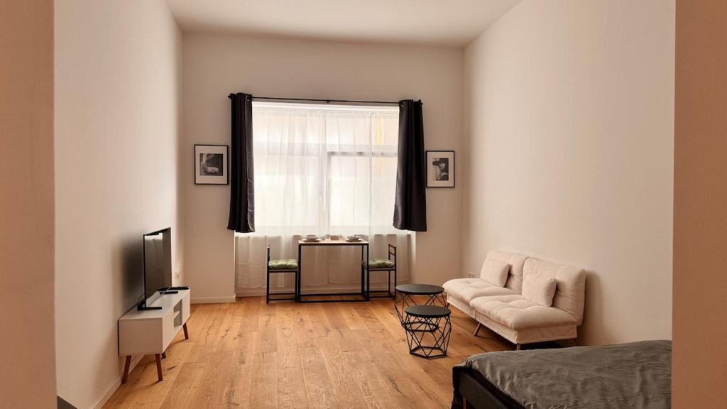 een woonkamer met een bank, een tv en een raam bij Central premium apartment in München