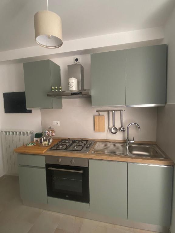 una cucina con mobili blu e un forno a piano cottura di Ai Sette Scalini a Larino