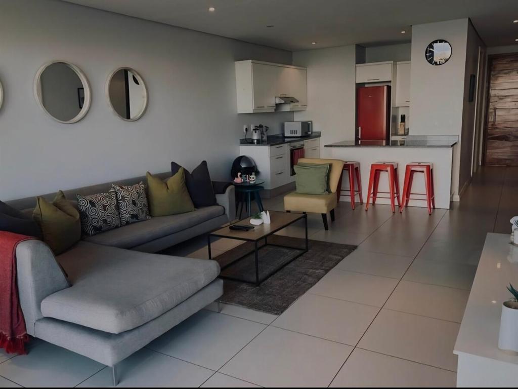 a living room with a couch and a kitchen at Executive apartment Umhlanga in Durban