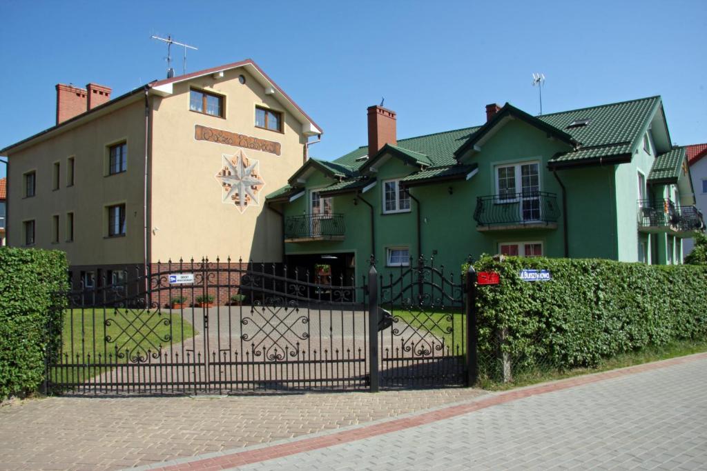 a house with a gate in front of it at Róża Wiatrów in Rowy
