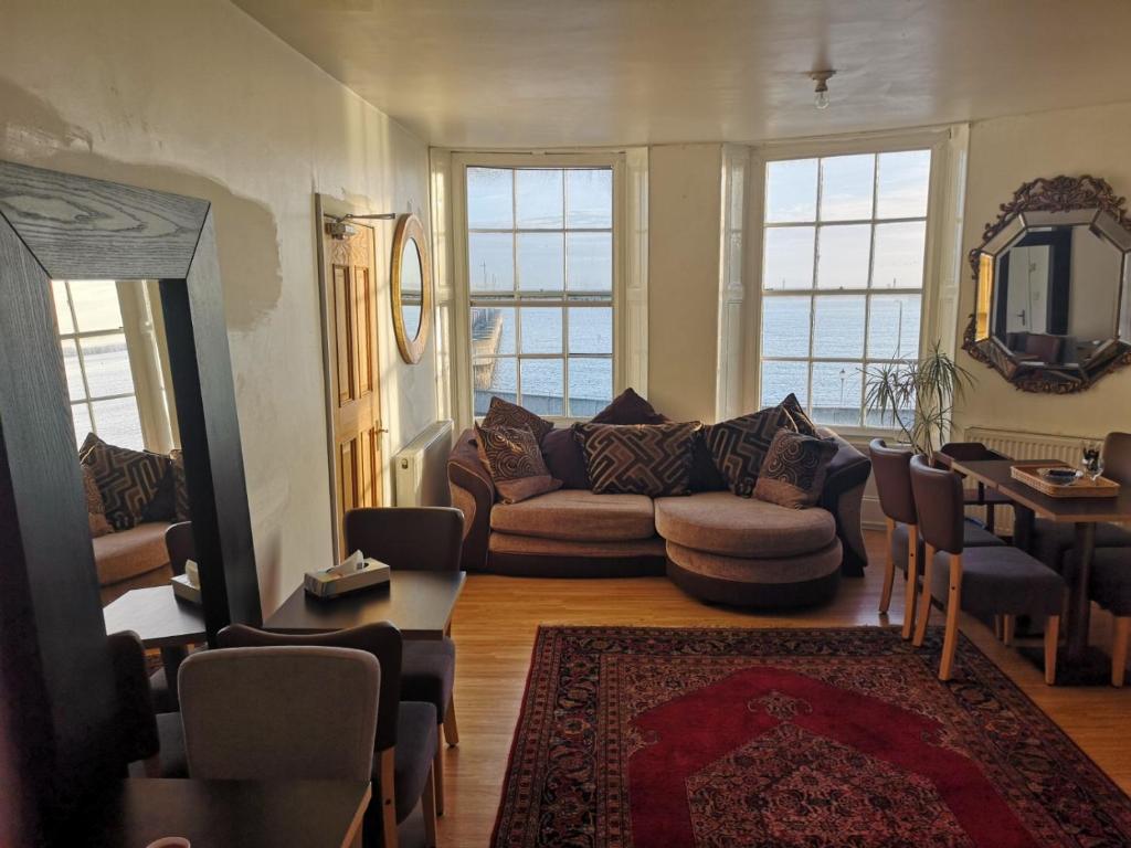 a living room with a couch and a table at Flat next to port and cliffs with parking in Dover