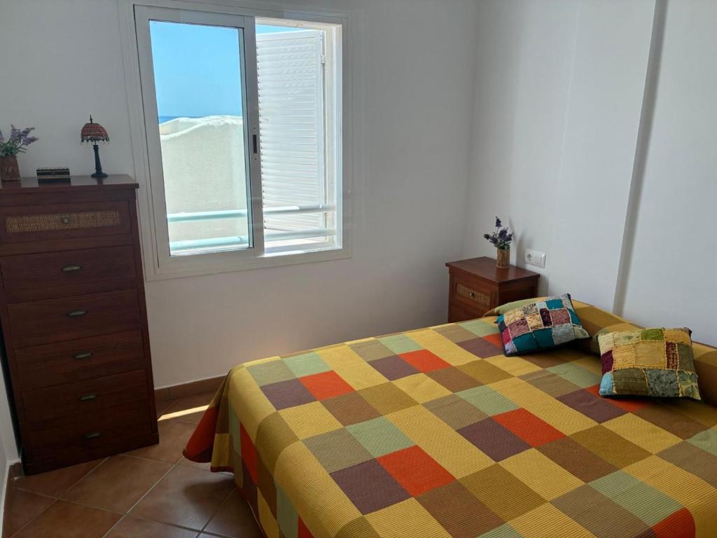 sypialnia z łóżkiem, komodą i oknem w obiekcie Apartamento con vistas al mar en la Isleta del Moro w mieście Níjar