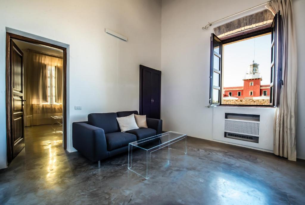 a living room with a blue couch and a window at Faro Capo Spartivento in Chia