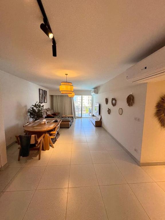 ein großes Wohnzimmer mit Tisch und Couch in der Unterkunft Apartment at Marassi in El-Alamein
