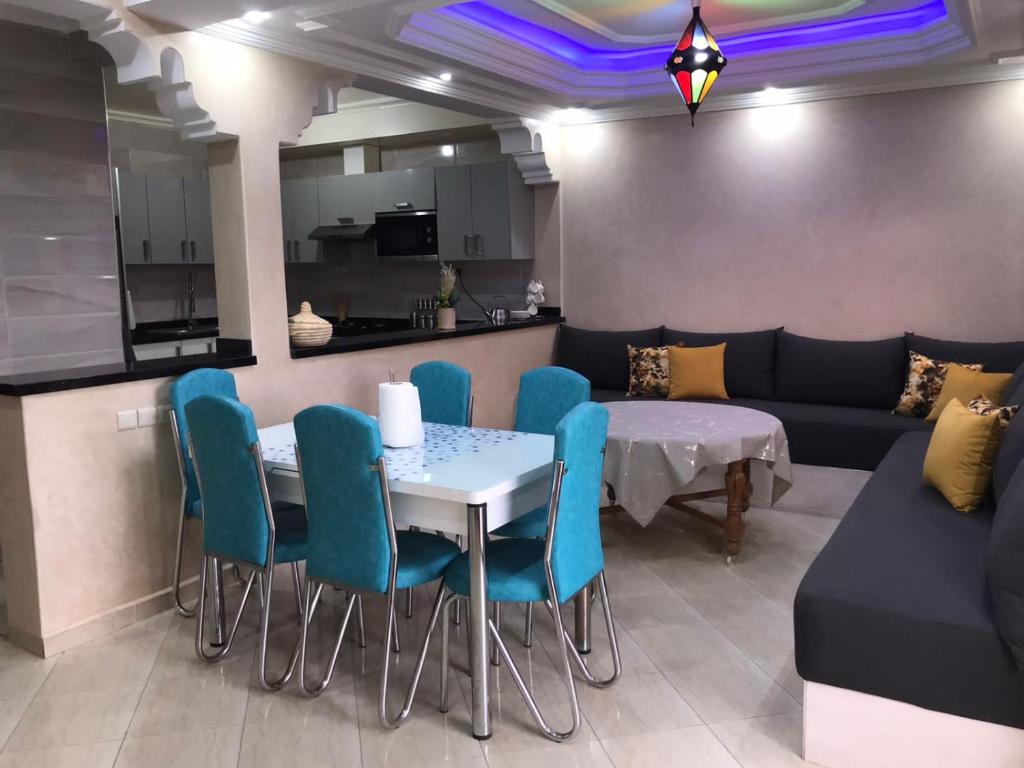 un salon avec une table, des chaises et un canapé dans l'établissement L'Oasis del Maria Fatima, à Agadir nʼ Aït Sa