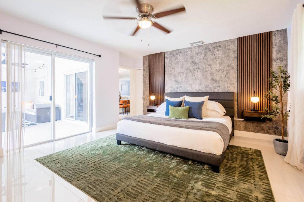 Un dormitorio con una cama y un ventilador de techo. en Modern Family Pool Home Near Beach Vibes, en Hollywood