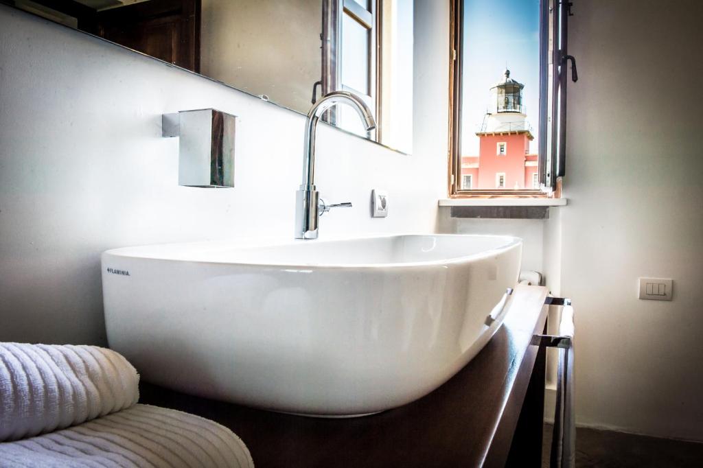 a bathroom with a large white tub and a lighthouse at Faro Capo Spartivento in Chia