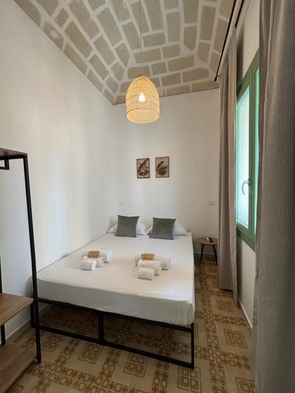 法维尼亚纳DIMORA DELLA CAVA Favignana的一间卧室配有一张带白色床单和天花板的床。