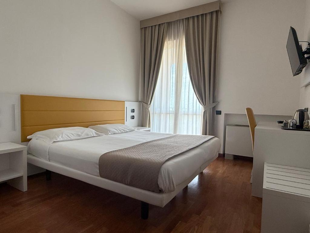 a bedroom with a large bed and a large window at Hotel Palazzo Bello - NUOVA GESTIONE in Recanati