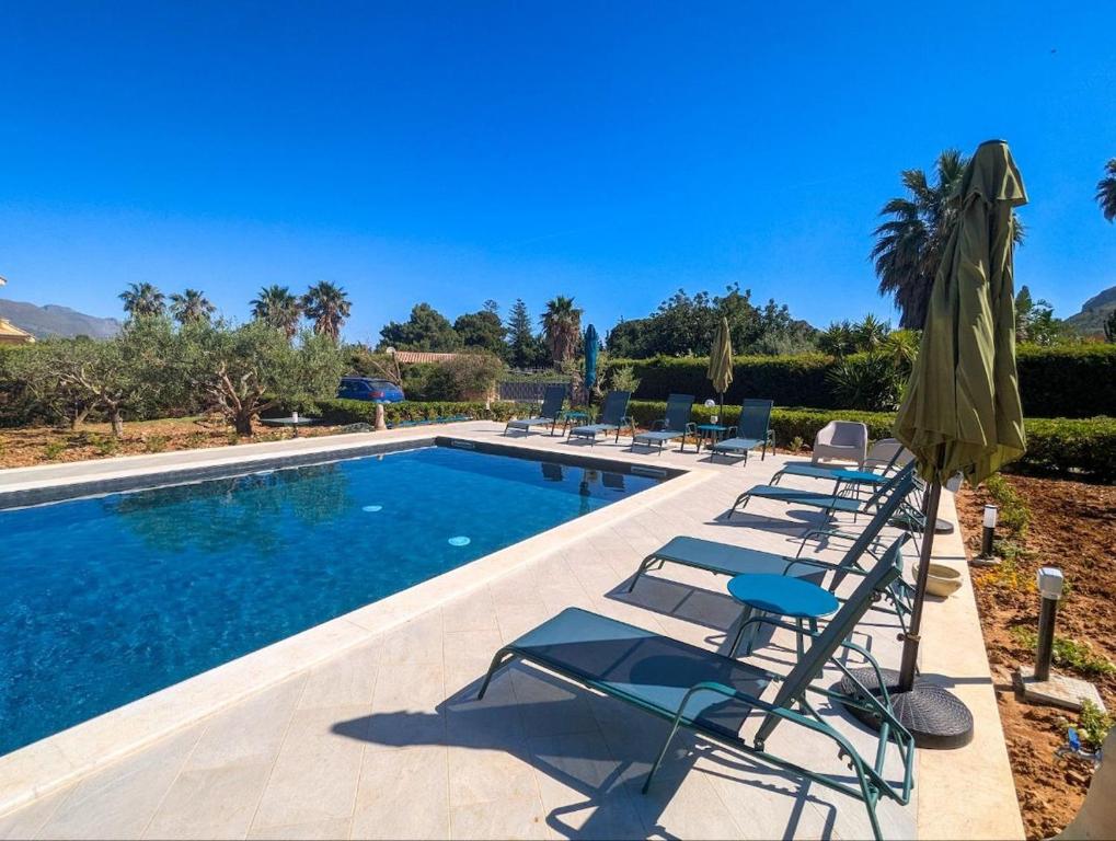 une piscine avec des chaises longues et un parasol dans l'établissement Villa Betta Cuntrariusa con piscina privata e jacuzzi a Scopello, à Castellammare del Golfo