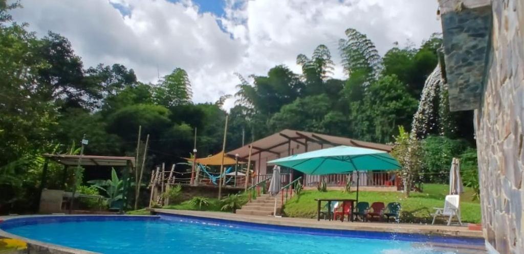 a resort with a swimming pool and a house at Casa quinta del 11 in La Vega
