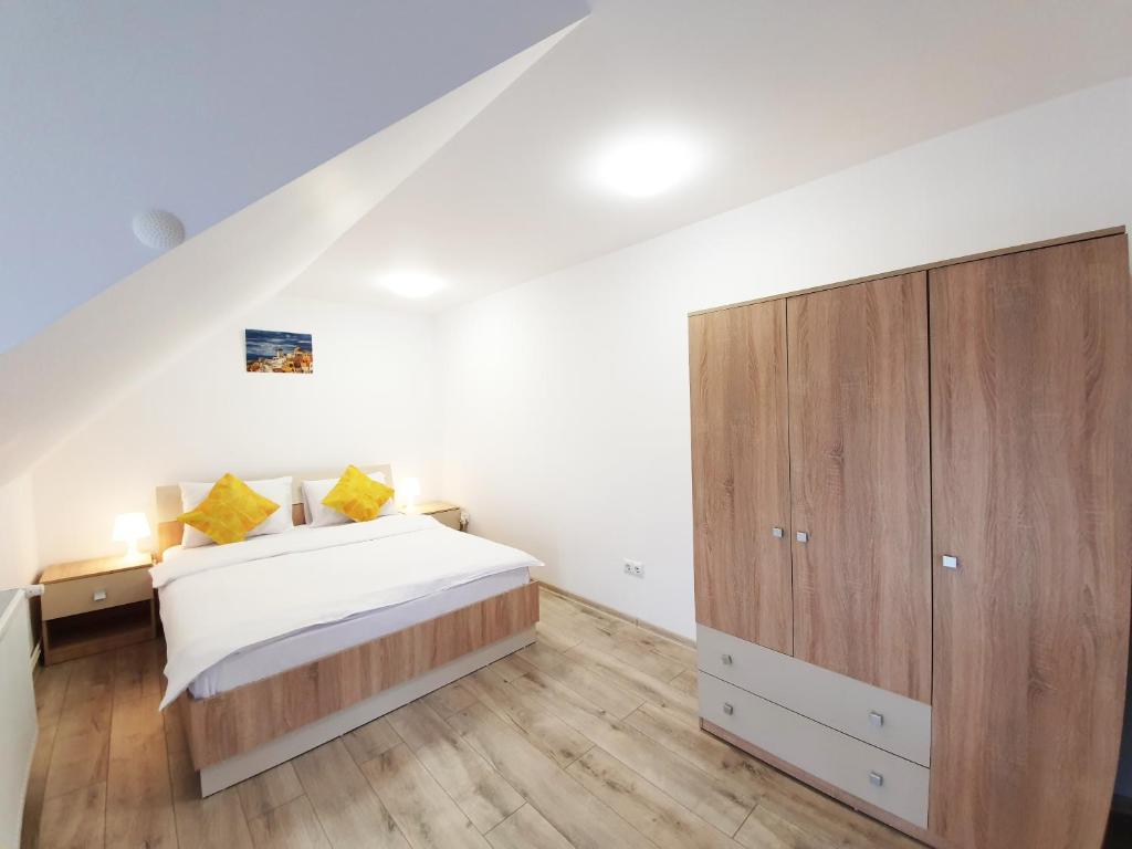 a bedroom with a bed and a wooden cabinet at Mont Melis in Sînpetru