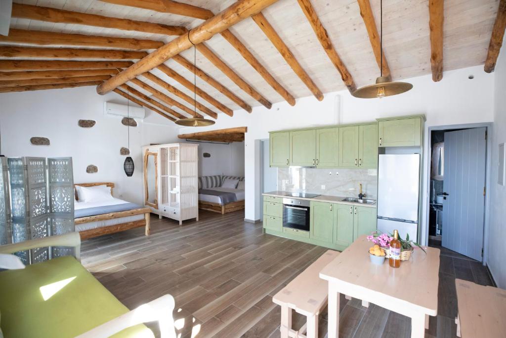a kitchen with green cabinets and a wooden floor at Erifi Luxury Suites in Armenistis