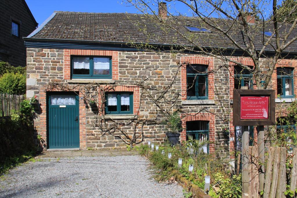 une vieille maison en briques avec une porte verte dans l'établissement Gîte les beaux-arts, à Ronzon